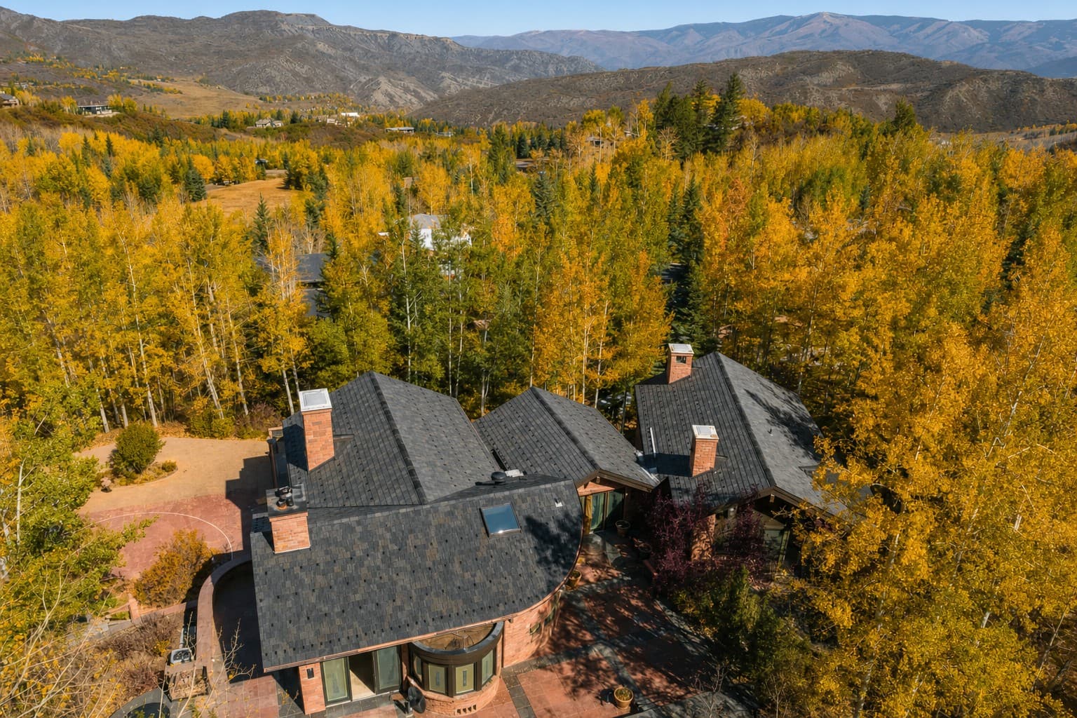 A cedar-shake replacement roof among aspens, seen from above