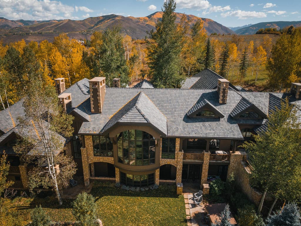 A stone and timber home among autumn aspens in the Roaring Fork Valley